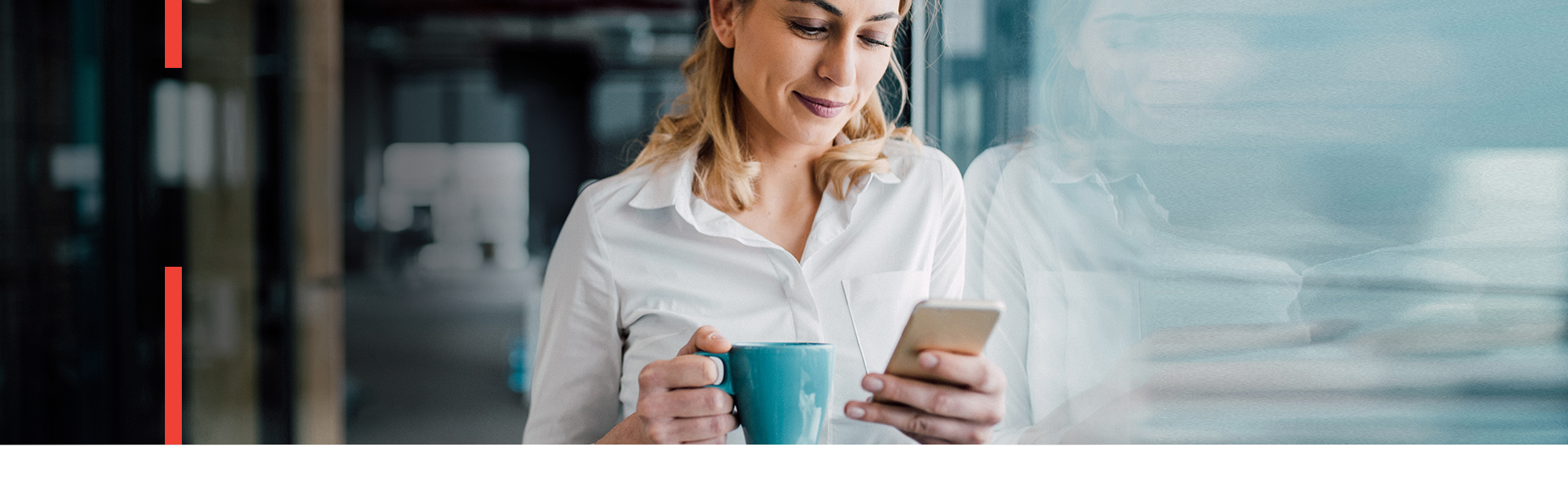 Woman drinking coffee and looking at her mobile phone